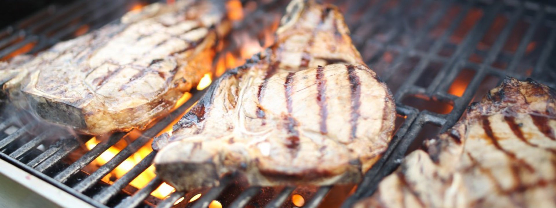 Frisch gegrillte Fleischst&uuml;cke mit Grillstreifen auf dem Rost