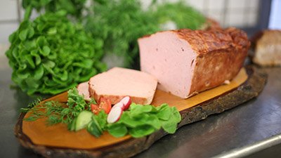 Fleischwurst aus eigener Herstellung mit Salat und frischen Kr&auml;utern
