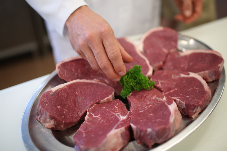 Frische Fleischstücke für die Verkaufstheke Frische Fleischstücke werden in der Fleischerei für den Verkauf vorbereitet