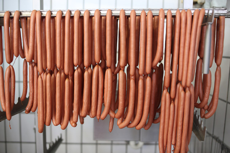 Würstchen aus eigener Herstellung Frisch hergestellte Würstchen hängen zur weiteren Verarbeitung auf einem Gestell